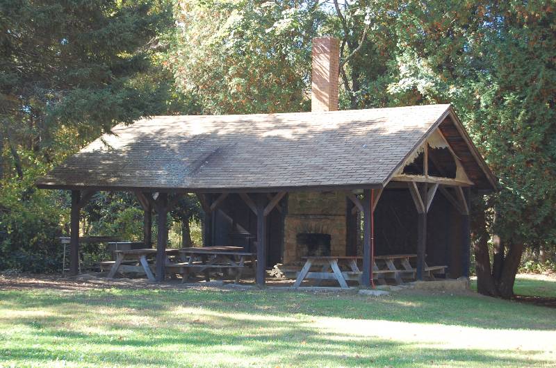 Scout shelter at Camp Aquapaug with picnic tables and fireplace.