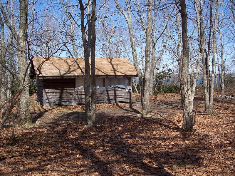 Rustic cabin at Camp Aquapaug surrounded by trees for Scout camping and outdoor adventures.