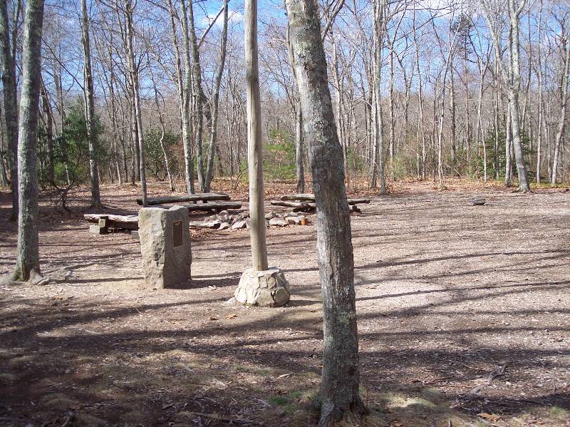 Outdoor Scout camping area at Camp Aquapaug, featuring picnic tables and fire pit.