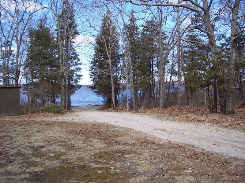 Wooded shoreline at Camp Aquapaug with trees and water view.